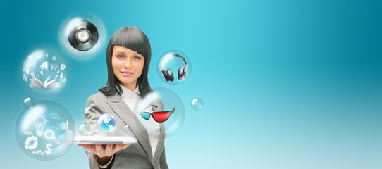 Pretty business woman holding tablet computer and different obje
