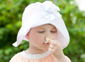 Pretty little girl smelling flower