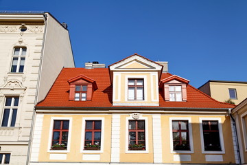 Maison au toit rouge, ciel bleu.