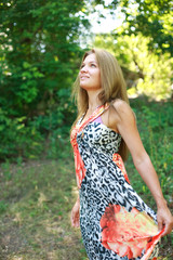 Beautiful young blonde  enjoying a summer day in green forest