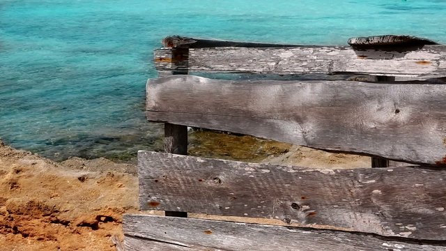 grunge gray wood on turquoise beach of Formentera island