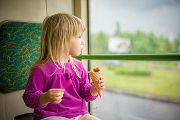 Adorable girl eat ice cream riding bus