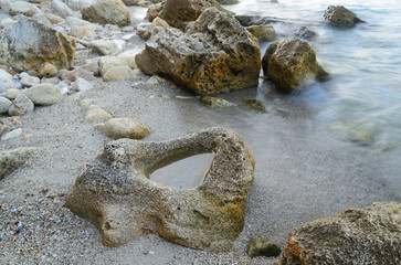 Rocks in the water. Waves Motion blur by long exposure.