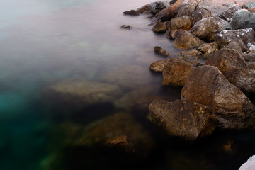 Rocks in the water. Waves Motion blur by long exposure.