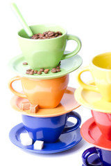 Colorful coffee cups, spoons, sugar and cinnamon stick