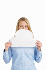 Attractive mature woman hiding behind a blank white paper cloud