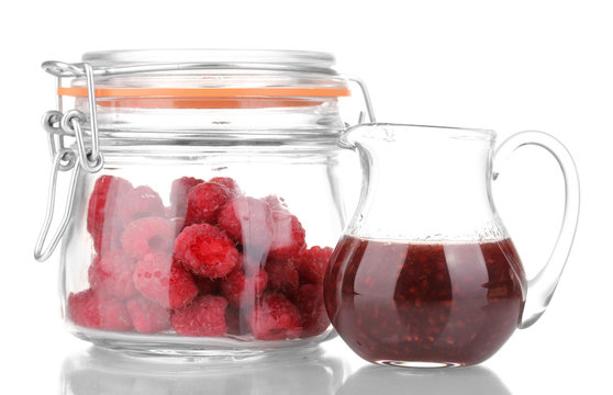 Raspberries in jar and jug with jam isolated on white