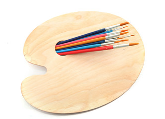 wooden art palette and brushes isolated on white
