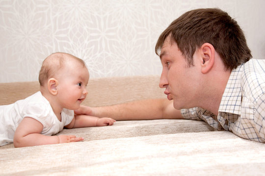 Father and baby daughter, talking, smiling