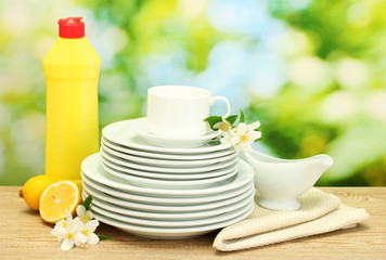 empty clean plates and cups with dishwashing liquid, flowers