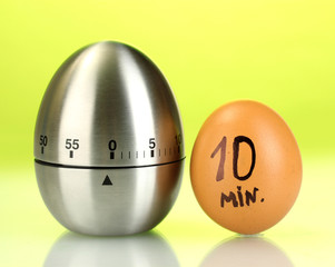 egg timer and egg on green background