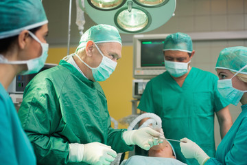Smiling surgeon working with a team
