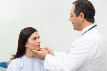 Fototapeta premium Doctor auscultating the neck of a patient