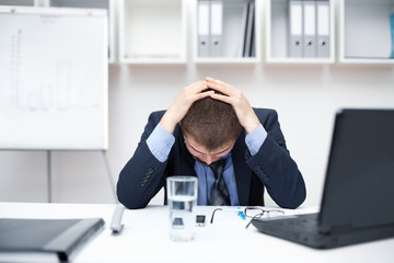 Young business man with problems and stress in the office