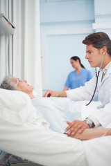 Fototapeta premium Doctor auscultating a patient with a stethoscope