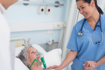 Nurse touching the hand of a patient