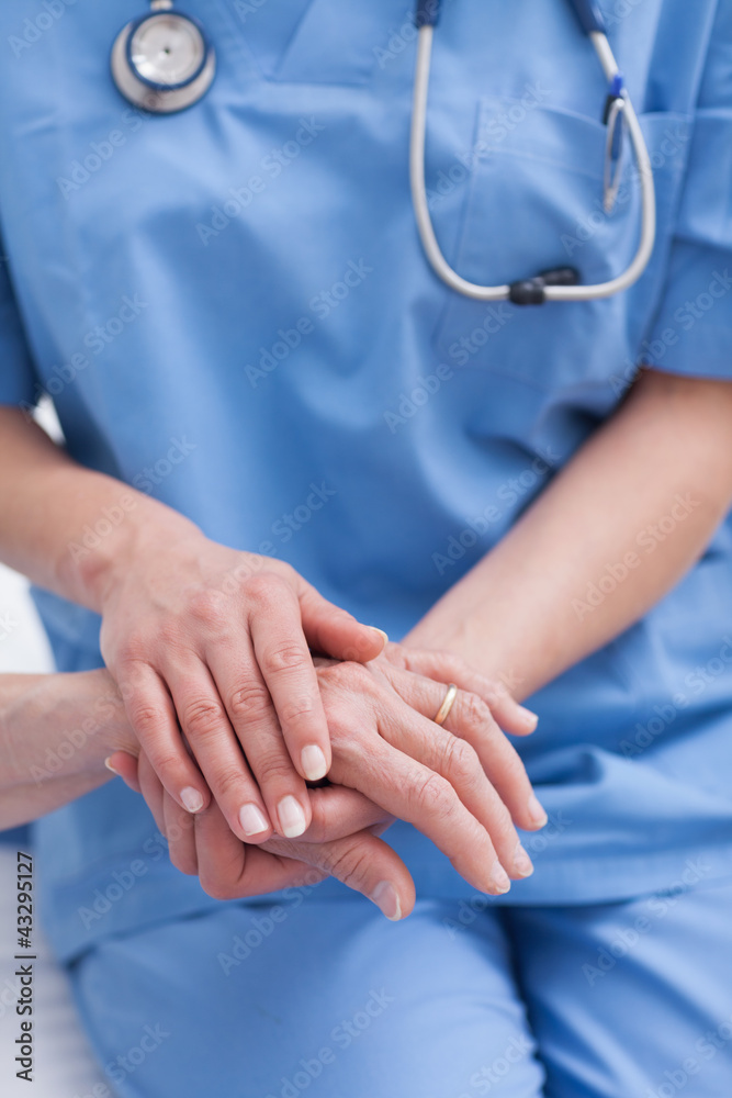 Wall mural Close up of a nurse holding hand of a patient