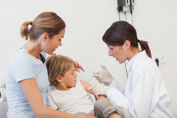 Obraz premium Child receiving an injection by a doctor