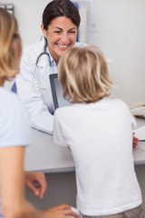 Smiling doctor presenting a tablet computer to a child