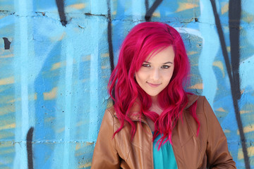Pink hair girl against a blue wall