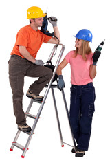 Male and female carpenters flirting