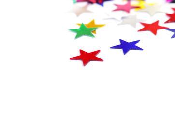 Christmas decoration of colored confetti stars against white bac