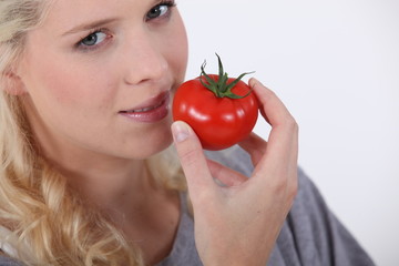 Woman eating a tomato