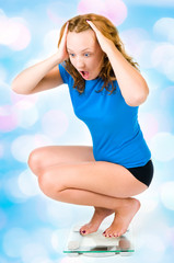 A young girl screams as she sees her weight on the scale