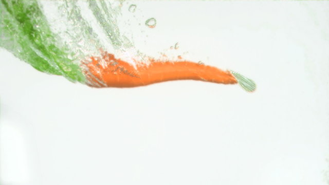 Natural carrot in super slow motion falling in the water