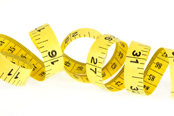 Yellow coiled tape measure on white