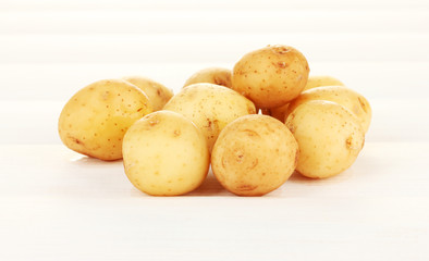 young potatoes on white wooden table close-up