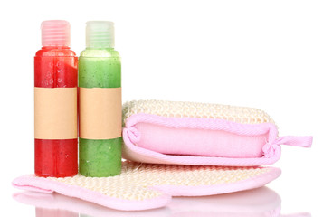 Bottles with scrub and sponges isolated on white