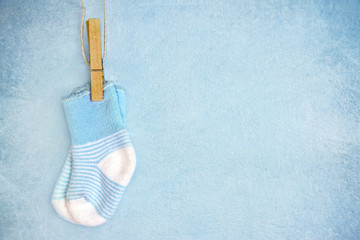 Blue baby socks on a textured background - obrazy, fototapety, plakaty