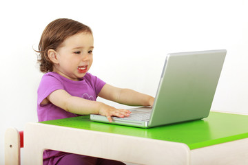 Kind sitzt vor einem Laptop und surft im Internet