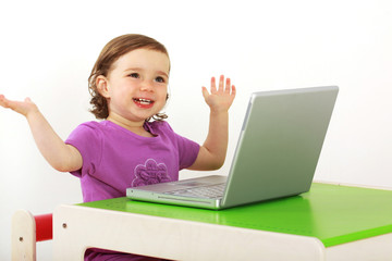 Kind sitzt vor einem Laptop und surft im Internet