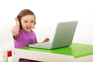 Kind sitzt vor einem Laptop und surft im Internet