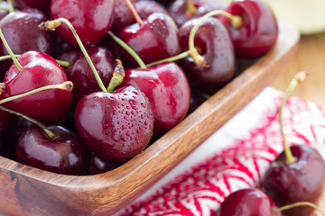 closeup of fresh cherries in basket on wood table