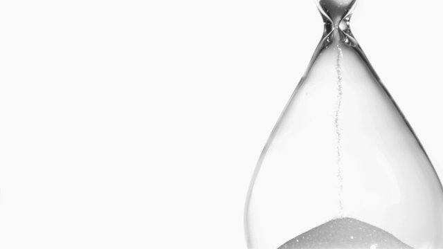Sand in super slow motion falling from a hourglass