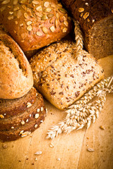 Collection of baked bread on wooden background