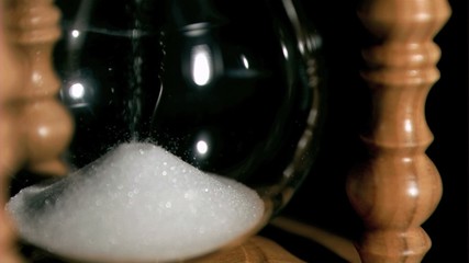 Sand in super slow motion falling from an egg timer