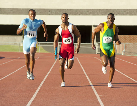 Runners running on track in relay race