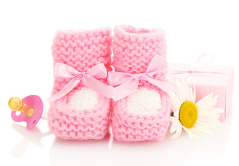 pink baby boots, pacifier, gift and flower isolated on white