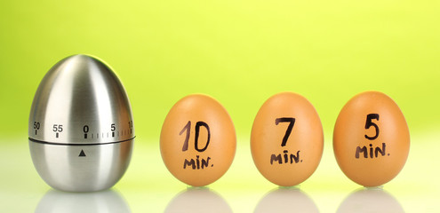 egg timer and eggs on green background