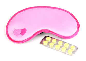 Sleeping mask and tablets isolated on white