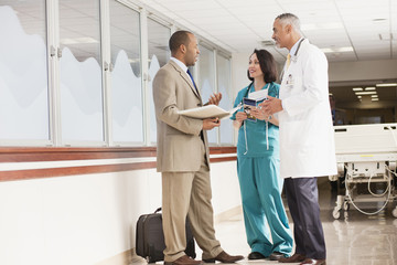 Doctors and drug salesman talking in hospital