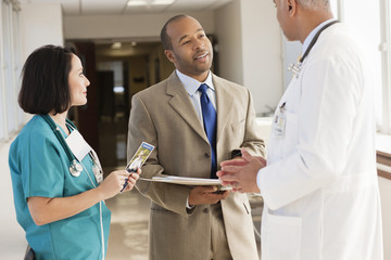 Doctors and drug salesman talking in hospital