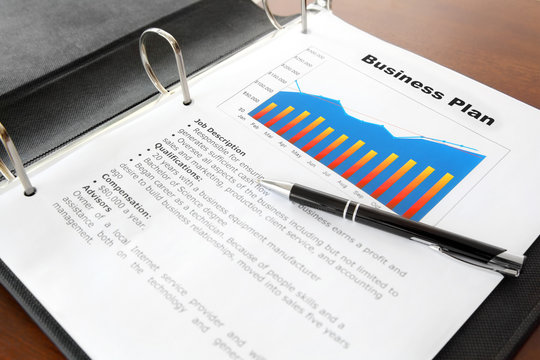 Business Plan with Pen in the Binder on the Table