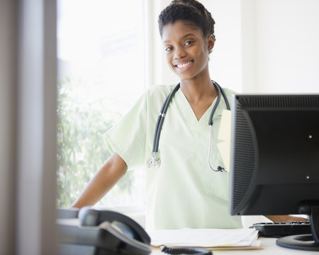 Black nurse standing at desk