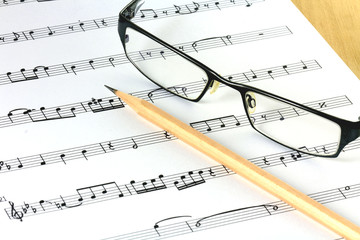 music sheet with pencil and glasses
