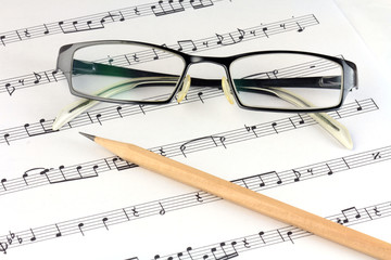music sheet with pencil and glasses